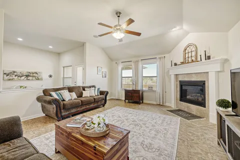a living room with furniture a fireplace and a ceiling fan