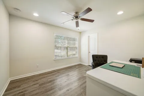 a living room with stainless steel appliances kitchen island hardwood floor and a window