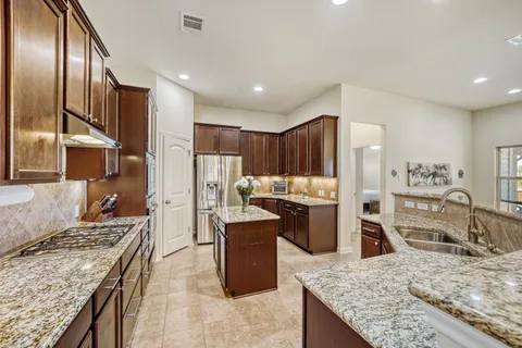 a kitchen with granite countertop counter top space a sink stainless steel appliances and cabinets