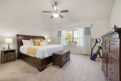 a spacious bedroom with a bed a chandelier and a window