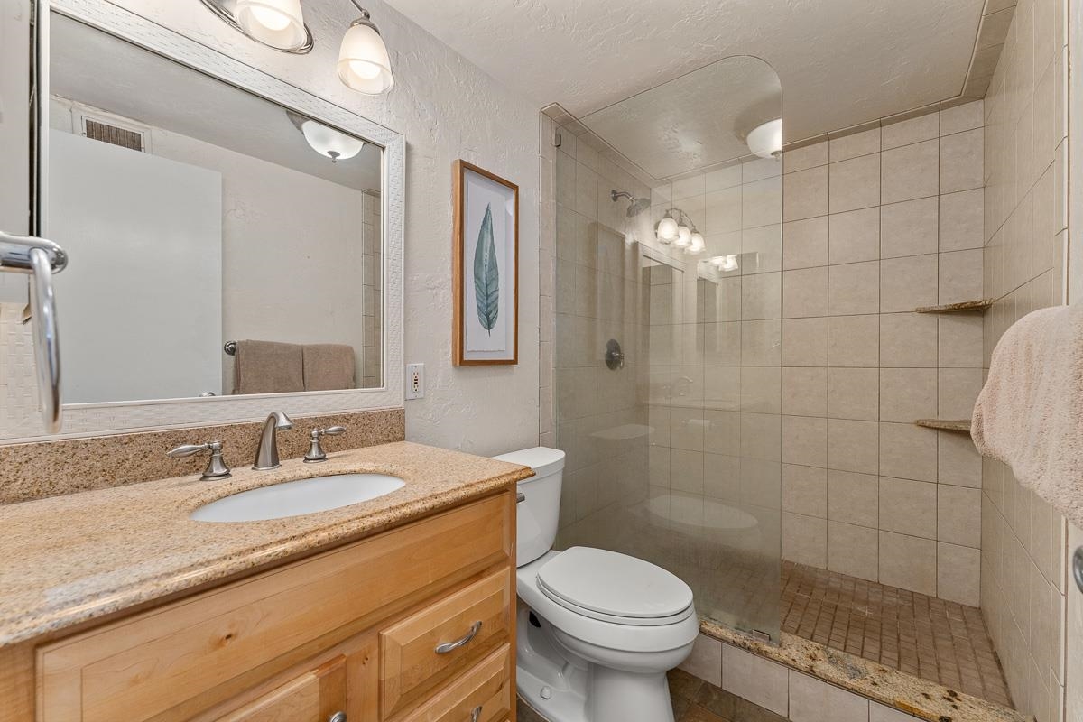 73 North Kihei Road, Unit 602 Kihei, HI 96753 - Photo 31 of 47 a bathroom with a granite countertop sink a toilet and shower