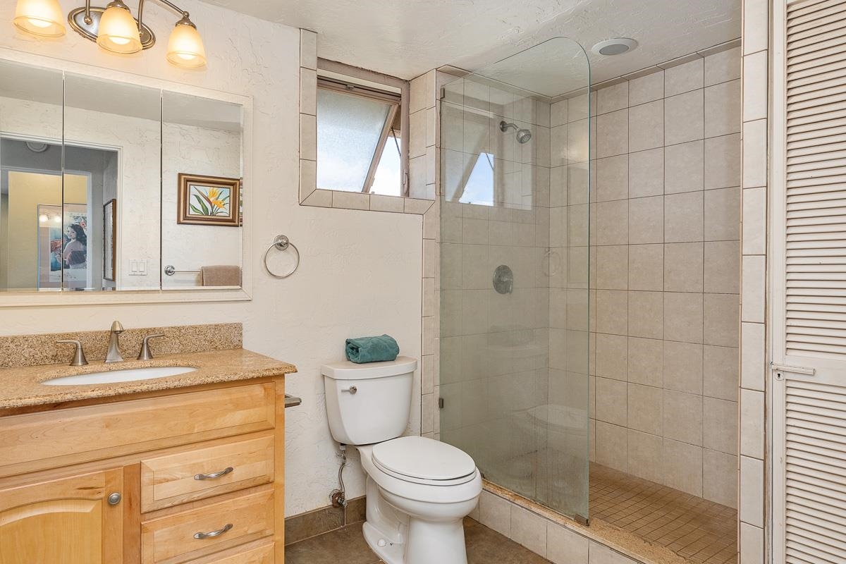 73 North Kihei Road, Unit 602 Kihei, HI 96753 - Photo 37 of 47 a bathroom with a granite countertop toilet sink and a mirror