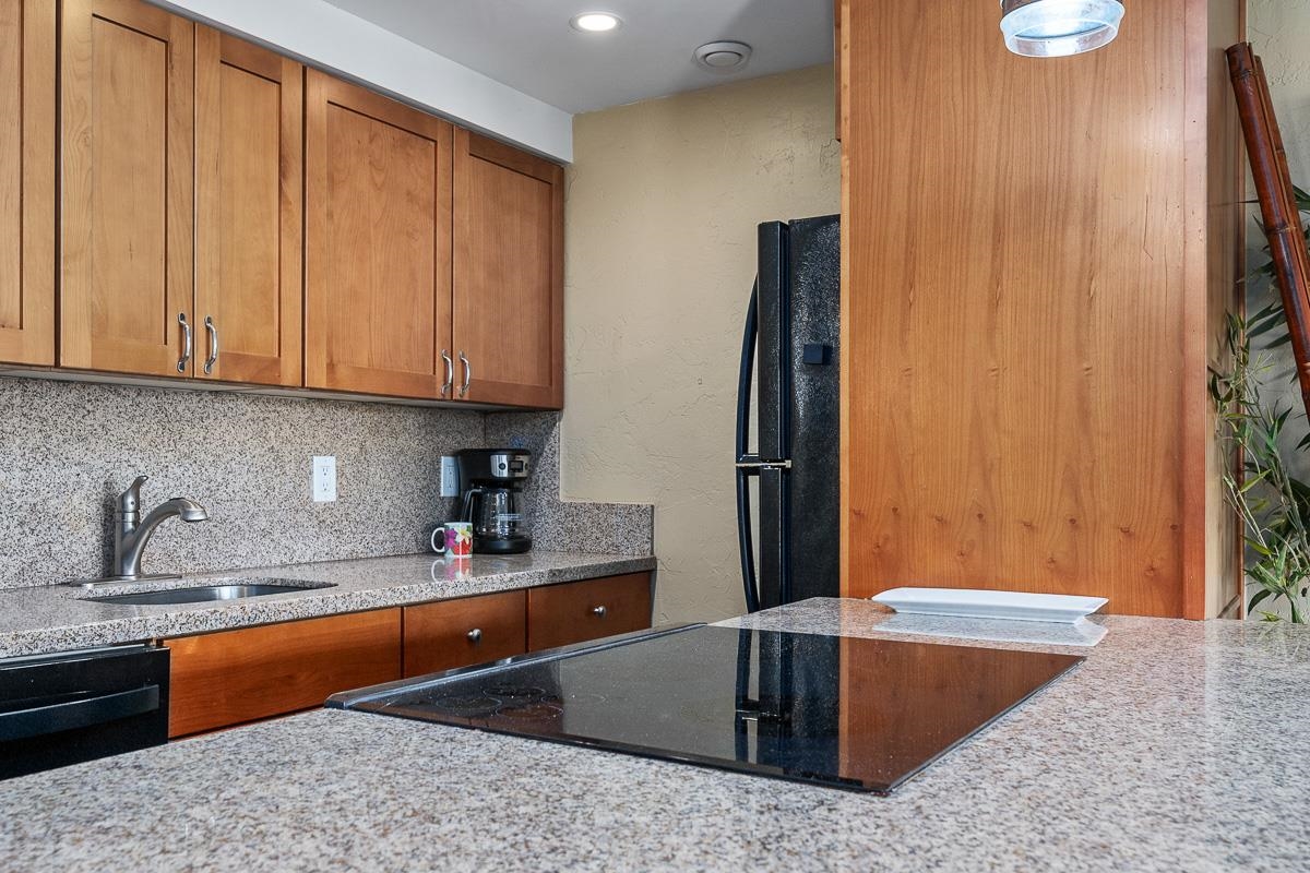 73 North Kihei Road, Unit 602 Kihei, HI 96753 - Photo 5 of 47 a kitchen with stainless steel appliances granite countertop a refrigerator and a sink