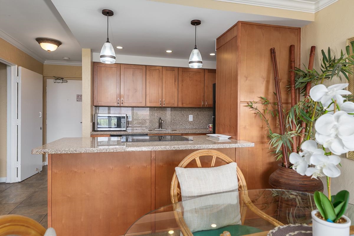 73 North Kihei Road, Unit 602 Kihei, HI 96753 - Photo 8 of 47 a kitchen with kitchen island a counter top space a sink stainless steel appliances and cabinets