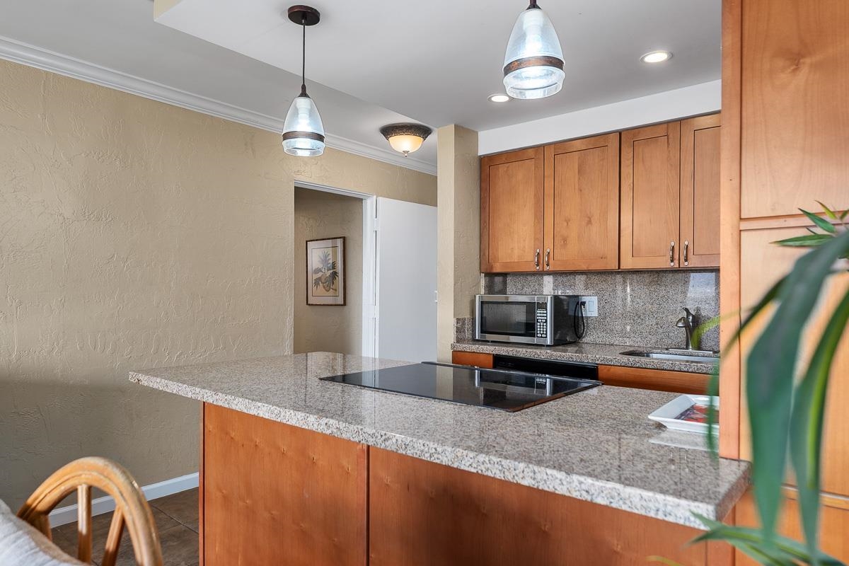73 North Kihei Road, Unit 602 Kihei, HI 96753 - Photo 9 of 47 a kitchen with stainless steel appliances granite countertop a sink a microwave counter space and cabinets