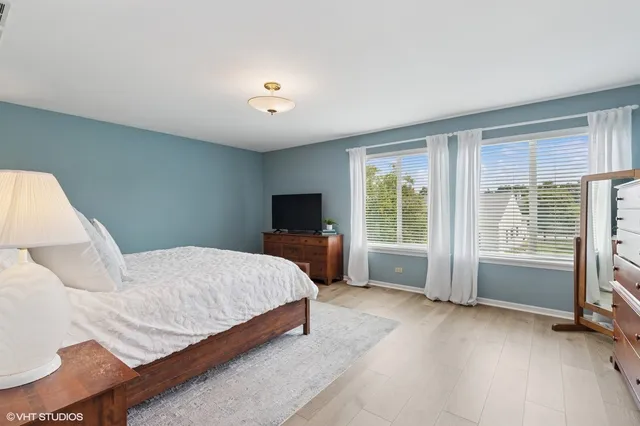 a spacious bedroom with a bed and a large window