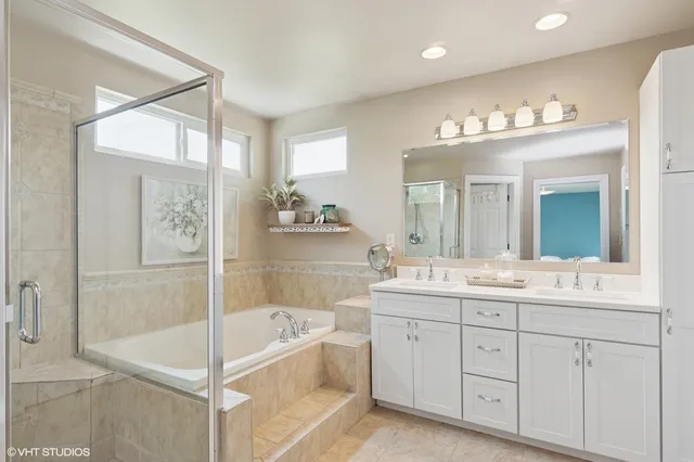 a spacious bathroom with a shower sink double vanity and mirror