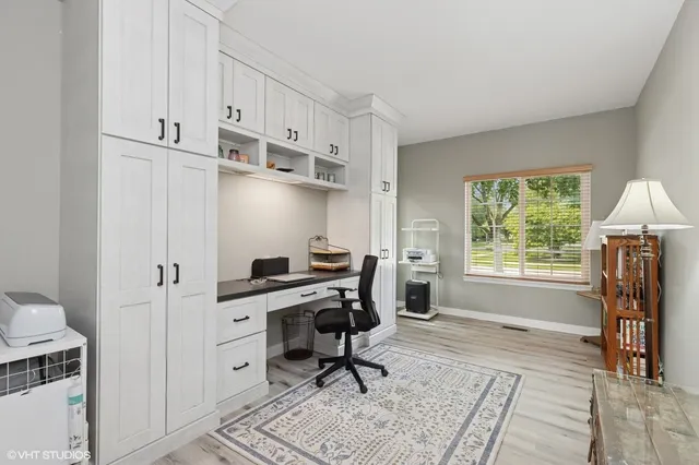 a view of a workspace with furniture and a window