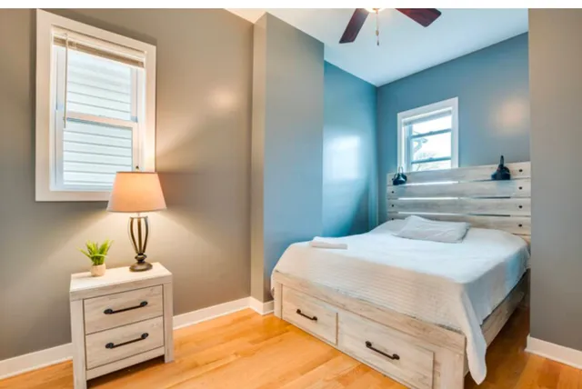 a bedroom with a bed and a lamp on dresser