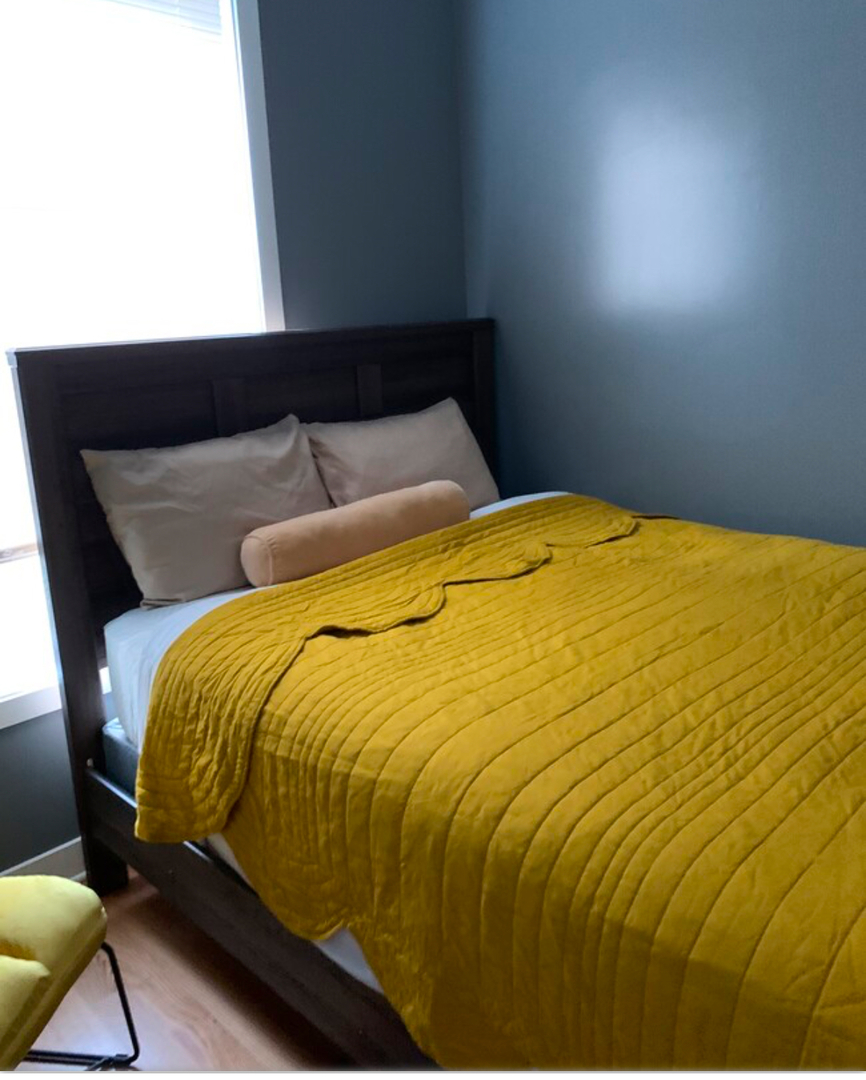 4241 South Langley Avenue, Unit 2 Chicago, IL 60653 - Photo 8 of 11 a blue bed sitting in a bedroom next to a window