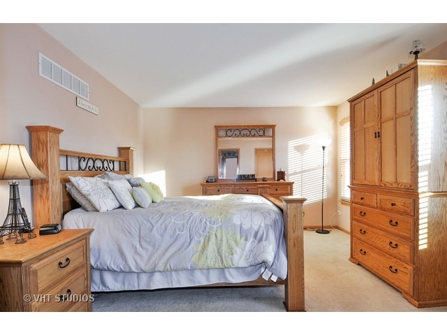 1913 Spring Ridge Drive Plainfield, IL 60586 - Photo 6 of 10 a bedroom with a bed and a dresser