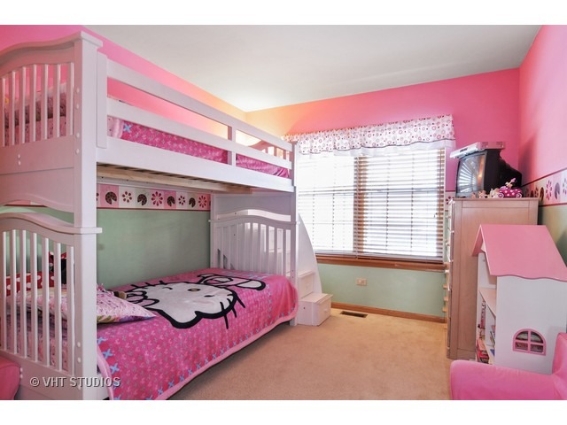 1913 Spring Ridge Drive Plainfield, IL 60586 - Photo 8 of 10 a bed sitting in a bedroom next to a window