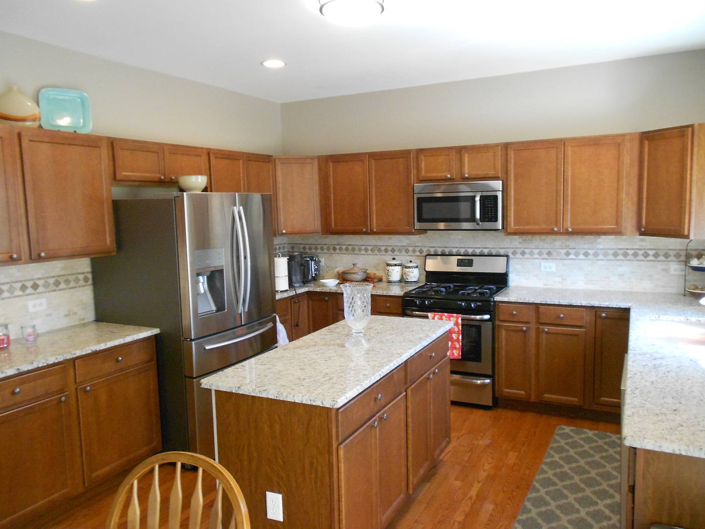 1721 Pin Oak Lane Elgin, IL 60120 - Photo 17 of 39 a kitchen with stainless steel appliances granite countertop a refrigerator stove microwave sink and cabinets