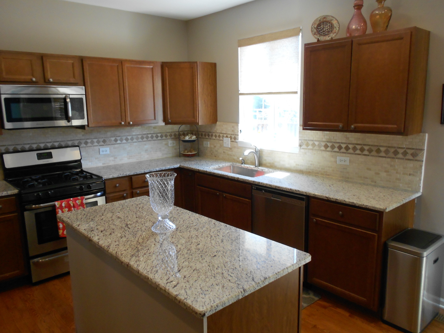 1721 Pin Oak Lane Elgin, IL 60120 - Photo 18 of 39 a kitchen with a sink a microwave a stove and refrigerator