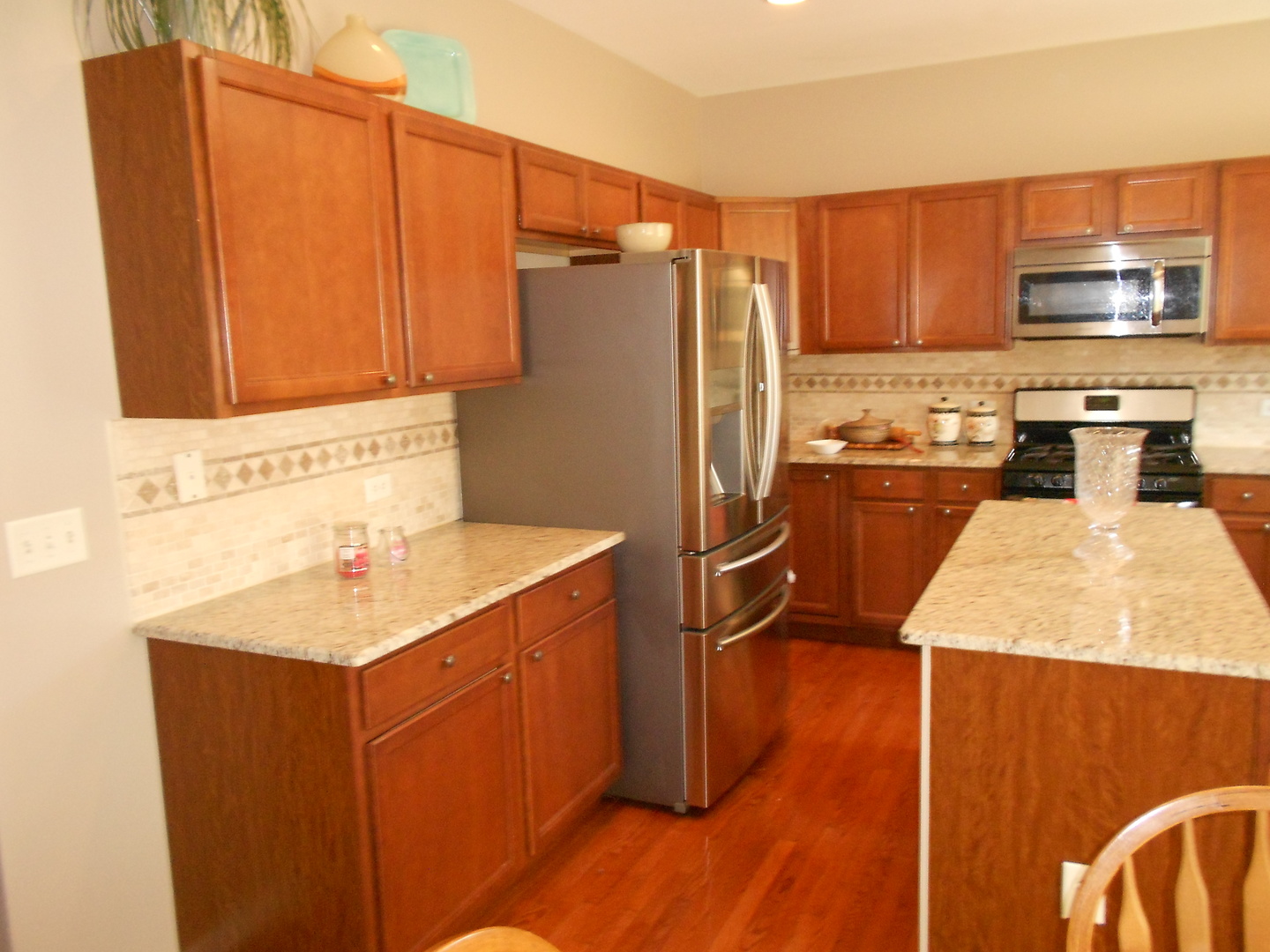 1721 Pin Oak Lane Elgin, IL 60120 - Photo 19 of 39 a kitchen with stainless steel appliances wooden cabinets a refrigerator and a sink