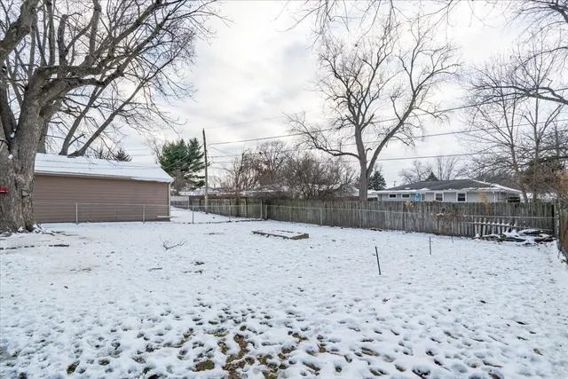 a wooden house covered with snow in front of house