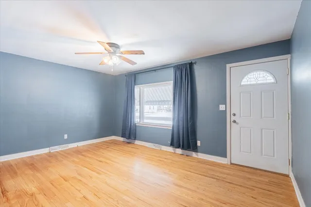 a view of empty room with window and ceiling fan