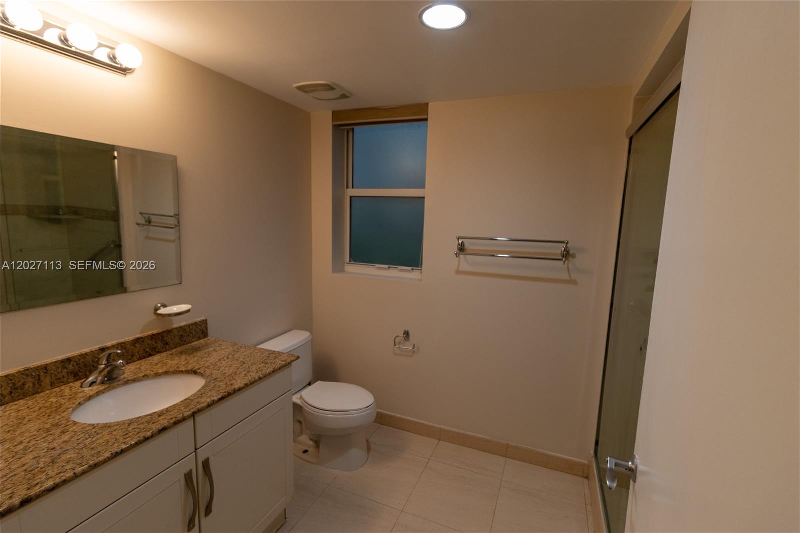 7275 Southwest 90th Way, Unit 213 Miami, FL 33156 - Photo 23 of 31 a bathroom with a granite countertop sink toilet and mirror