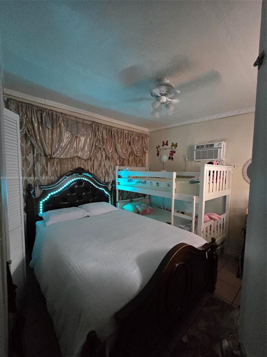 102 West 27th Street Hialeah, FL 33010 - Photo 17 of 26 a bedroom with a bed and a chandelier