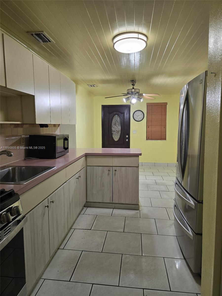 102 West 27th Street Hialeah, FL 33010 - Photo 5 of 26 a kitchen with stainless steel appliances granite countertop a stove refrigerator and microwave
