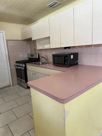 a kitchen with stainless steel appliances granite countertop a sink a stove a microwave and cabinets