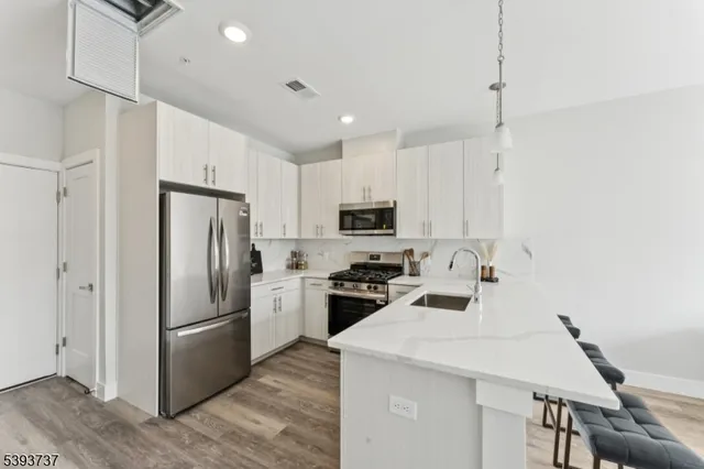 a kitchen with a refrigerator a stove top oven a sink and cabinets