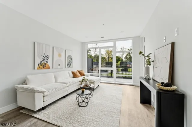 a living room with furniture a flat screen tv and a large window