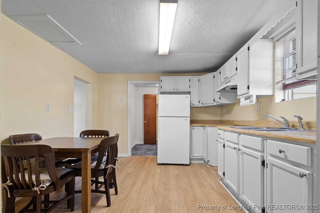 663 Possum Holler Road Eagle Springs, NC 27242 - Photo 8 of 21 a kitchen that has a table chairs and a refrigerator