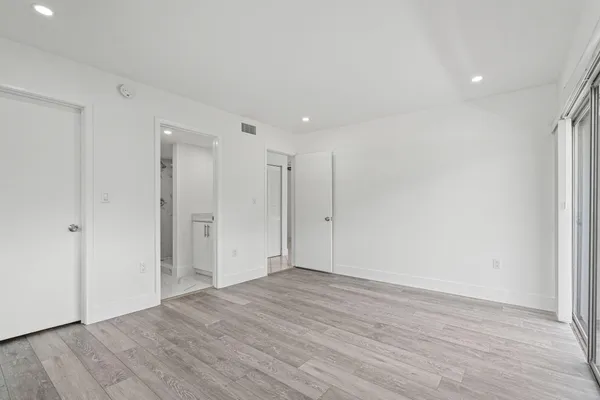 a view of an empty room with wooden floor