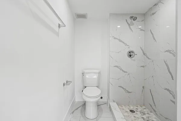 a bathroom with a toilet and a shower