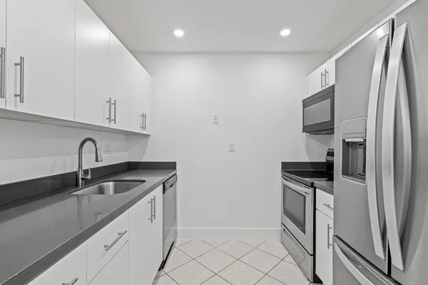 a kitchen with granite countertop a refrigerator sink and stove