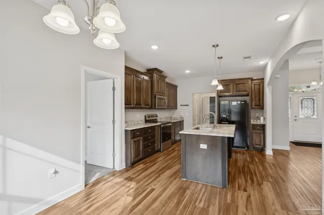 a large kitchen with cabinets wooden floor and stainless steel appliances