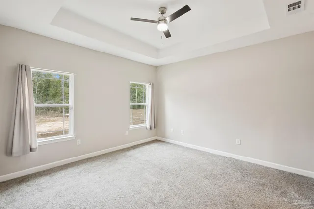 an empty room with a window and a ceiling fan