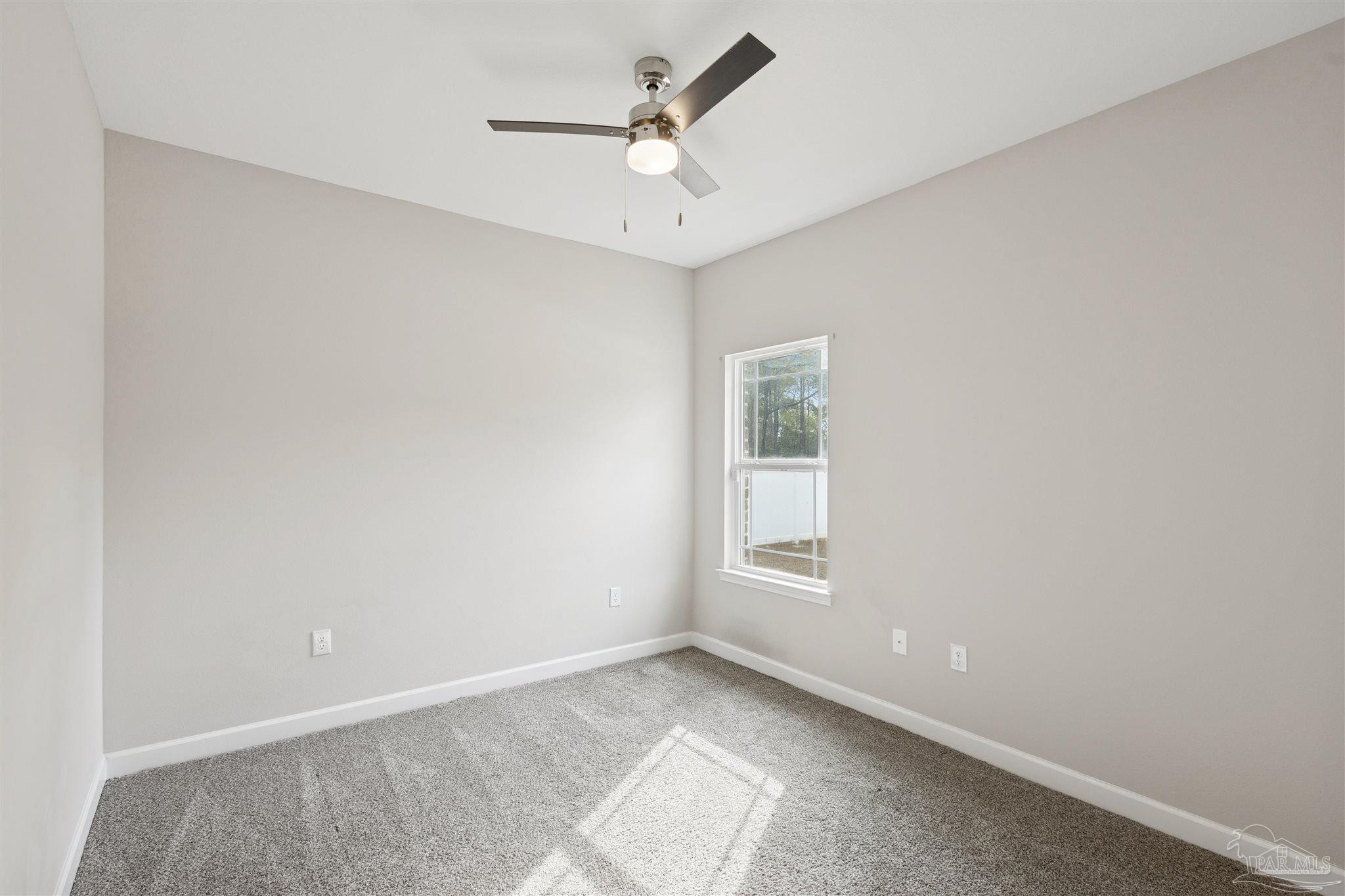 9855 Shangri La West Road Milton, FL 32583 - Photo 23 of 32 an empty room with a window and a ceiling fan