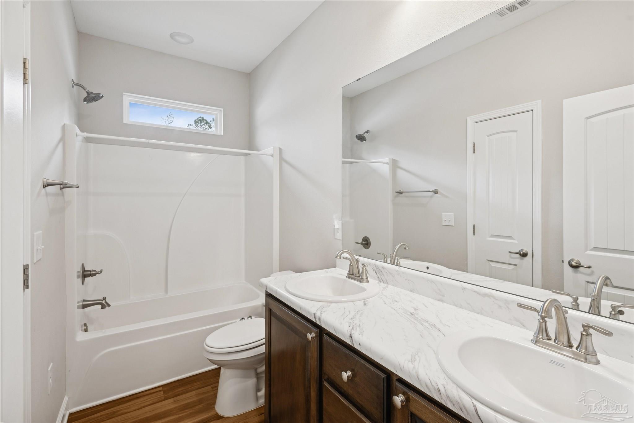 9855 Shangri La West Road Milton, FL 32583 - Photo 24 of 32 a bathroom with a granite countertop sink toilet and shower