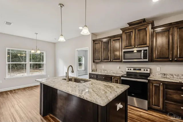 a kitchen with microwave a stove and a sink