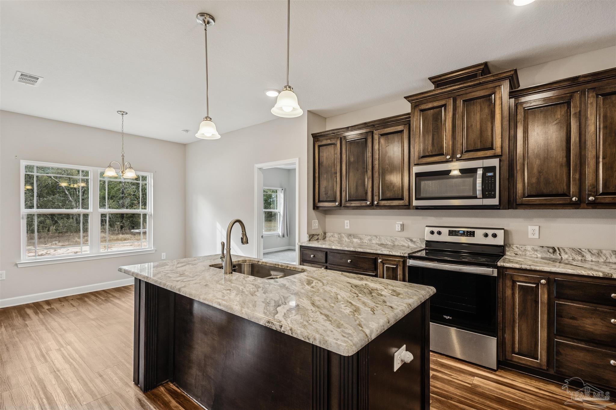 9855 Shangri La West Road Milton, FL 32583 - Photo 5 of 32 a kitchen with microwave a stove and a sink