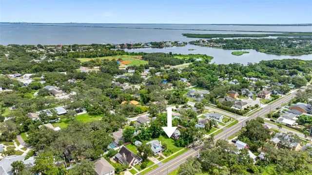an aerial view of a residential houses with outdoor space and trees