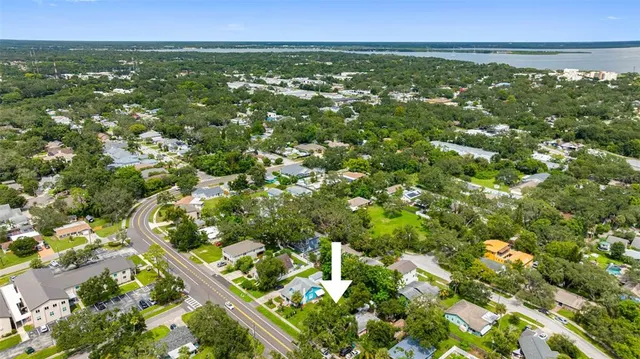 an aerial view of residential houses with outdoor space and trees