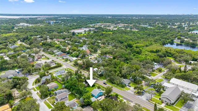 an aerial view of residential houses with outdoor space and trees