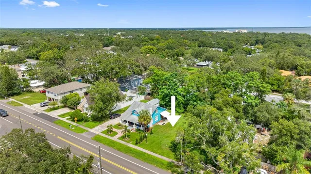 an aerial view of residential houses with outdoor space and trees