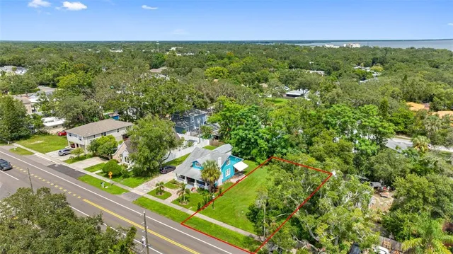 an aerial view of residential houses with outdoor space and trees