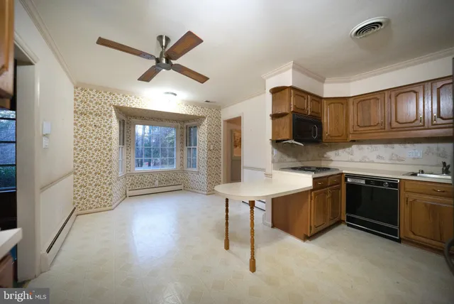 a kitchen with stainless steel appliances granite countertop a sink cabinets and wooden floor