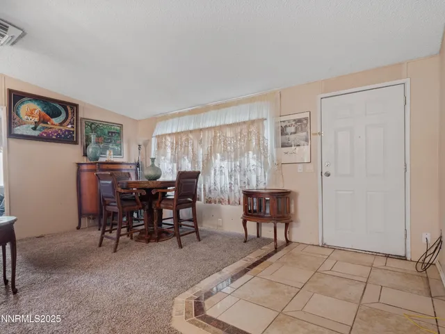 a kitchen with granite countertop a stove a sink dishwasher a refrigerator and a dining table with wooden floor