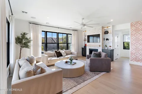 a living room with fireplace furniture and a large window