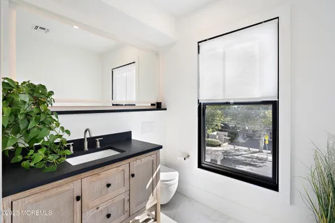 a bathroom with a sink a mirror and a picture of the wall