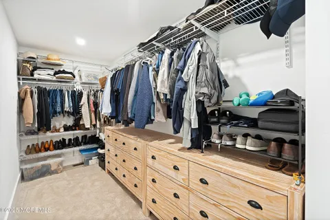 a view of walk in closet with clothes and shoes