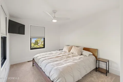 a bedroom with a bed and painting on the wall