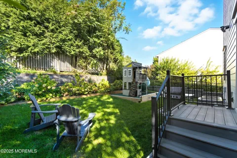 a backyard of a house with table and chairs potted plants and large tree