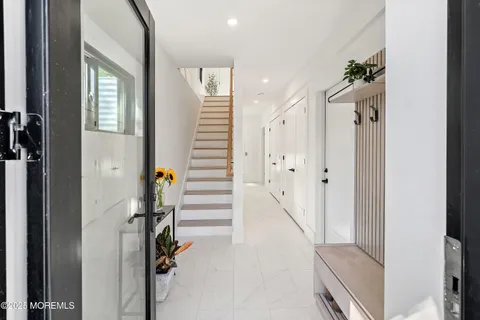 a view of a hallway with wooden floor and staircase
